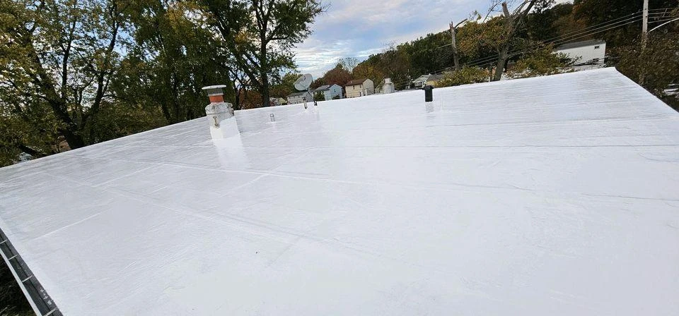 Newly installed white flat roof showcasing the sleek and waterproof surface, demonstrating a high-quality flat roof installation that impacts cost considerations.