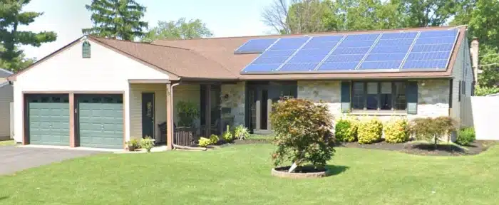 Residential property with solar panels and asphalt shingles, showcasing sustainable roofing materials Cherry Hill residents might consider for energy efficiency